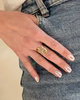 Anillo dorado de acero con diseño ondulado.