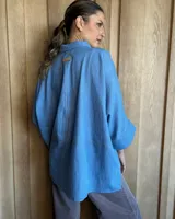 Camisa celeste de mangas largas con cuello clásico y cierre frontal con botones.