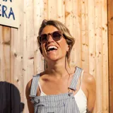 Lentes de sol redondos con montura de madera color marrón y lentes degradados color marrón.