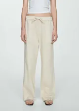 Pantalón color crema de corte recto, con cintura elástica ajustable con lazo, tiro medio y bolsillos cargo.