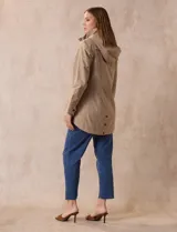 Campera impermeable color gris claro, marca Gallery. Tiene abertura central con cierre oculto y botones a presión, bolsillos delanteros y capucha plegable en el cuello.