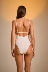 Malla enteriza blanca con textura arrugada y breteles finos.