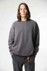 Buzo de algodón gris oscuro con efecto lavado, corte oversize y cuello redondo. Presenta un pequeño logo bordado en forma de 'X' en el pecho.