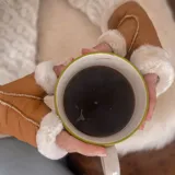 Guantes mitones de cuero de oveja color dorado con borde de piel sintética color crema.