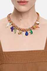 Collar corto de cadena dorada con cordón multicolor trenzado y colgantes de charms con motivos de la jungla en resina, metal y esmalte. Cierre de mosquetón.