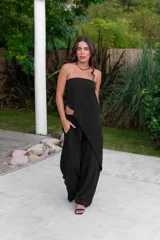 Conjunto de dos piezas color negro, compuesto por un top strapless con diseño asimétrico y un pantalón ancho de tiro alto.