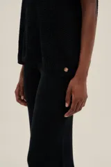 Pantalón tejido negro con detalle de crochet blanco en el ruedo, de largo hasta los tobillos, con un fit holgado y cintura elastizada.
