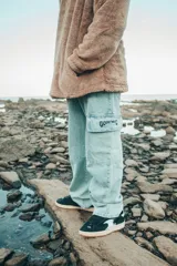 Pantalón cargo de denim celeste con bolsillos laterales con solapa y logo bordado en negro.