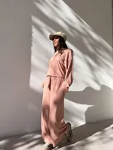 Conjunto deportivo color rosa compuesto por un buzo de cuello alto y mangas largas, y un pantalón palazzo con cintura elastizada y cordón ajustable.