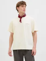 Remera color hueso de algodón con cuello redondo y manga corta. Estampado en la espalda con diseño de hojas de palmera y texto "Brezza Del Mattino Originals Summer Edition EST 1990".