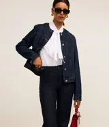 Pantalón de jeans azul oscuro, de corte recto, con cierre tradicional, trabillas en la cintura y hebilla lateral.