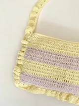 Cartera tejida a crochet con hilo 100% de algodón, con diseño a rayas y volados bordeando la cartera extendiéndose hacia la manija.