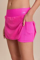 Pollera deportiva color verde lima, con short interno y bolsillo en la cintura.