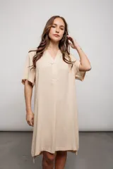 Vestido color beige de corte recto, con escote en V y mangas cortas.