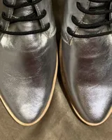 Botas acordonadas marrones de cuero vacuno con suela clara.