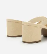 Sandalia mule color beige con puntera redonda, tira ancha en forma de H con efecto ráfia y tacón bloque mediano.
