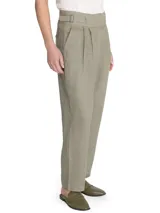 Pantalón de lino color verde, de tiro alto y pierna recta, con cierre cruzado y hebillas en los costados.