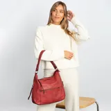 Cartera negra de cuero sintético con apertura superior y cierre con solapa. Tiene un bolsillo frontal con broche magnético y cierre, dos bolsillos internos y un bolsillo divisor en el forro. Incluye bolsillos laterales con cierre y correa larga regulable.