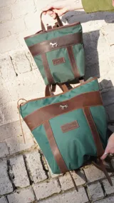 Mochila pequeña color borgoña con detalles en cuero marrón, asa de mano y correas ajustables.