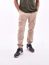 Pantalón jogger color beige con bolsillos cargo laterales, cintura elástica con cordón ajustable y puños elásticos.