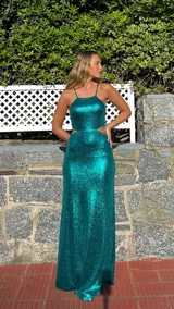 Vestido largo de fiesta color verde esmeralda brillante, con escote halter, espalda descubierta y aberturas laterales en la cintura.