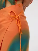 Falda midi marrón con estampado floral en tonos lila, abertura lateral y tiras ajustables.