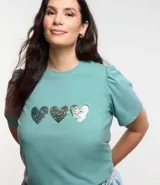 Remera de algodón color verde agua, con cuello redondo, mangas cortas abullonadas y tres corazones de lentejuelas plateadas en el frente.