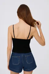 Musculosa blanca de algodón con breteles finos, corte al cuerpo y escote profundo.