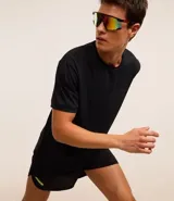 Remera deportiva negra de poliéster y elastano, con tecnología dry, cuello redondo, manga corta, textura y estampa lettering en el pecho.