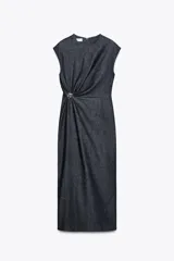 Vestido midi de denim azul oscuro, con cuello redondo y sisas. Presenta un aplique dorado en la cintura y abertura en la espalda. Cierre trasero con cremallera oculta.