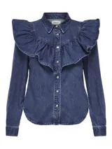 Camisa de denim azul con cuello clásico, cierre frontal con botones y volados grandes en el pecho y los hombros.
