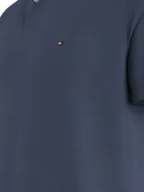 Chomba azul de piqué de algodón elástico, corte regular, cuello clásico y tapeta de dos botones. Logo de Tommy Hilfiger bordado en el pecho.
