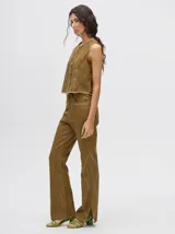 Pantalón de jean azul de tiro alto y corte oxford con apliques metálicos en bolsillos y laterales.