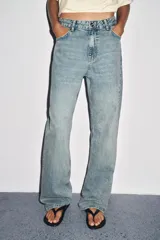 Pantalón de jean celeste de corte recto y tiro medio, con cinco bolsillos y cierre frontal con cremallera y botón metálico.