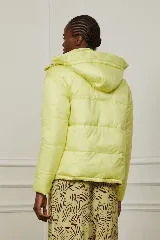 Campera puffer amarilla con estampado abstracto en color borgoña, con capucha y cierre frontal con botones a presión.