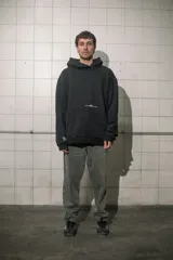 Buzo hoodie negro de algodón con bolsillo tipo canguro y estampado en el pecho y en la manga.