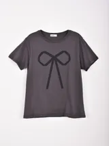 Remera de manga corta color gris oscuro, con cuello redondo y un gran estampado frontal de un moño estilizado en negro.