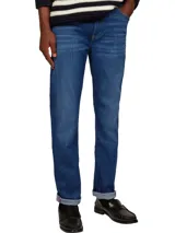 Jeans Bleecker de Tommy Hilfiger, confeccionados en algodón lavado para mayor comodidad y con elasticidad para un ajuste flexible. Diseño de 5 bolsillos, cierre con botón y cremallera, detalles distintivos de Tommy Hilfiger y logo de Tommy Hilfiger bordado.