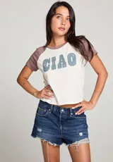 Remera blanca con mangas cortas color marrón y estampado frontal con la palabra "CIAO" en celeste con estrellas rosadas.