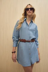 Vestido camisero negro de silueta amplia, con cuello camisero, botonadura frontal completa y mangas largas.