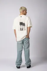 Remera color crema de corte oversize con la inscripción '90's' bordada en el frente y parche con imagen en la espalda.