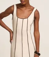 Vestido largo evasé sin mangas, confeccionado en viscolino con 15% de lino. Presenta escote cuadrado en el busto y escote en U en la espalda, con cierre trasero por cremallera. Posee bieses contrastantes.