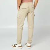 Pantalón cargo color beige, de corte slim fit, con cintura ajustable con cordón, bolsillos laterales con solapa y puños elásticos.