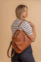 Cartera mochila color marrón de símil cuero suave con múltiples bolsillos con cierre, división al medio y correa ajustable de doble manija para llevar al hombro y como mochila.