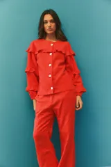 Campera de jean color rojo con volados en el frente y las mangas, confeccionada en algodón y lino.