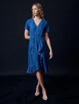 Vestido Luxology de tencel color azul, con escote en V cruzado, cintura elastizada con lazo, manga corta con volados y falda midi con volados.