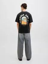 Remera negra de algodón con cuello redondo y manga corta. Estampado en la espalda con la frase "Almeria Art Exhb." y una imagen de un paisaje.