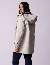 Gabardina impermeable color beige, marca Weatherproof, con abertura central con botones, bolsillos delanteros y capucha desmontable.