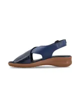 Sandalias color beige con tiras cruzadas en la capellada, una tira color dorado y otra color beige. Tiene una tira trasera con hebilla para ajustar al tobillo y suela baja.