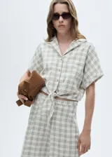 Blusa manga corta con diseño crop y de cuadros, cierre de lazo y cuello camisero.